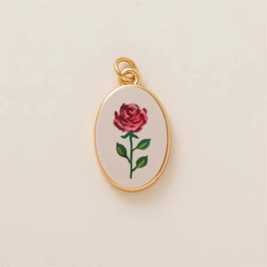 Primer plano de un colgante ovalado dorado con un diseño vintage de rosa roja bordada
