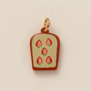 Macro detail of toast-shaped pendant with strawberry print and gold vacuum plating