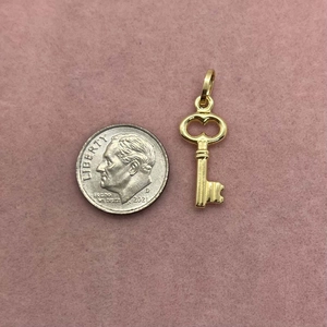 Gold key pendant shown next to a dime for size reference with smooth 18K plating
