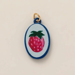 Detail showing an oval enamel strawberry pendant with gold plating for jewelry making