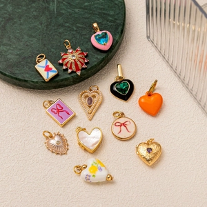 Collection of colorful enamel and gold-plated heart and star charms on a marble tray