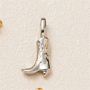 Macro shot of a silver cowboy boot pendant with embossed patterns and polished finish