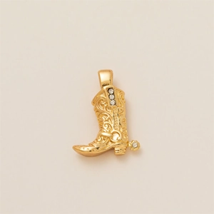 Detail of gold cowboy boot pendant featuring scroll engravings and white crystals