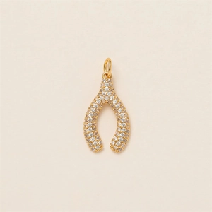 Macro detail of a gold wishbone pendant featuring micro-pave white zircon stones