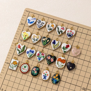 Macro view of vintage hand-painted ceramic pendants with colorful floral patterns and gold edges
