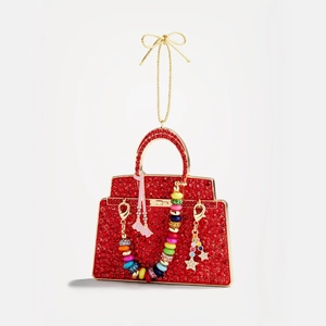 Dettaglio macro della borsa rossa con strass, catena dorata e ciondolo a stella
