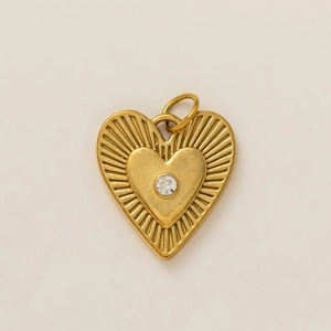 Close-up of golden double-layer heart pendant with sunray texture and zircon stone