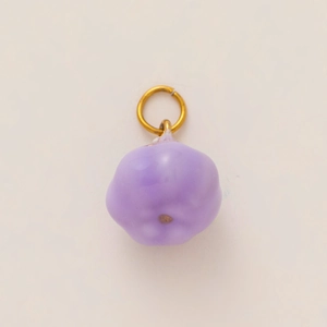 Detailed close-up of a purple pumpkin-shaped charm with an 18K gold-plated metal ring