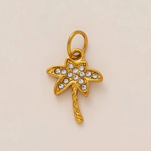 Dettaglio di un ciondolo a forma di palma in oro con cristalli pavé luccicanti