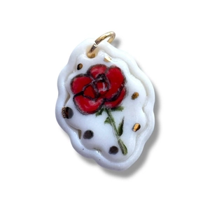 Vista macro del colgante de rosa de cerámica blanca con anillo de oro y dibujo floral