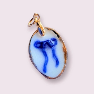 Colgante de corazón con lazo azul en cobre bañado en oro de 14k con acabado cerámico
