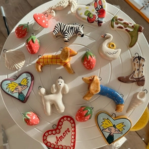 Vibrant 18k gold plated stainless steel swan and animal charms on a ceramic tray