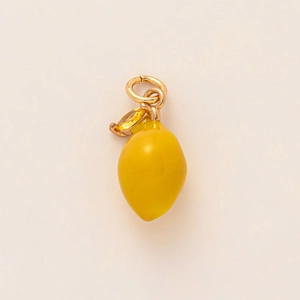Détail macro du pendentif citron jaune avec fermoir doré et pierre de zircone fine