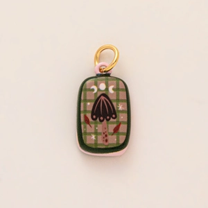 Détail du pendentif rectangulaire avec carreaux verts, motif champignon et anneau