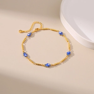 Détail d'une chevillère dorée ajustable avec cinq breloques Main de Fatima bleues et fermoir