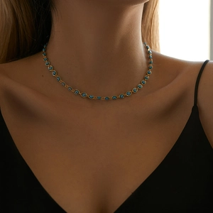 Elegant gold Evil Eye necklace featuring blue nazar beads worn by a model on the collarbone