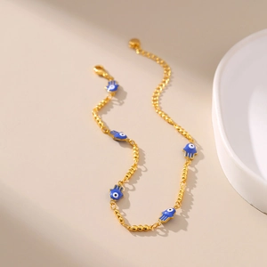 Détail de la chevillère dorée avec breloques Main de Fatma et mauvais œil bleues