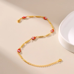 Détail de la chevillère dorée avec pendentif Hamsa rouge et fermoir mousqueton réglable
