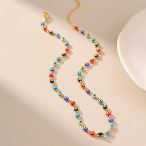Dettaglio della collana a catena dorata con perline colorate occhio di Allah
