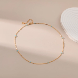 Detail van 18K vergulde ketting met lichtblauwe kralen en handige karabijnsluiting