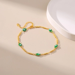 Détails des pendentifs main de Fatma en émail vert sur une chevillère dorée raffinée