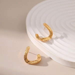 Dettaglio orecchini a forma di U placcati oro 18K con texture a rombi e finitura lucida