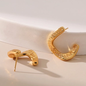 Eleganti orecchini a perno a forma di U placcati in oro 18 carati su sfondo di pietra bianca