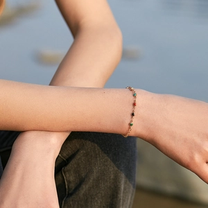 Detail eines 18K vergoldeten Messingarmbands mit bunten Perlen am Handgelenk