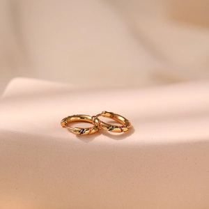 Orecchini a cerchio dorati minimalisti con zirconi colorati in un elegante design a onde