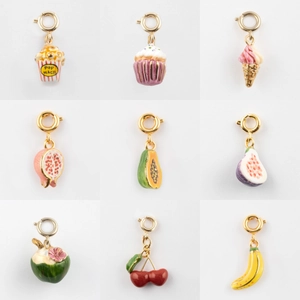 Vue détaillée de breloques en émail coloré en forme de fruits et snacks avec fermoirs dorés