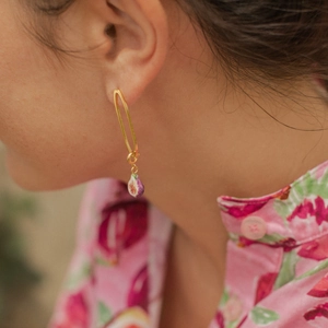Détail de boucle d'oreille longue plaquée or 18 carats avec pendentif figue émaillé