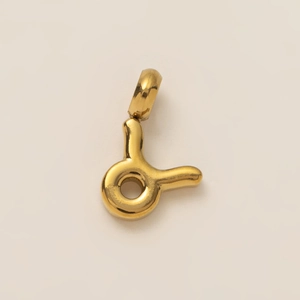 Detailed view of a polished gold irregular zodiac pendant with a smooth metallic finish
