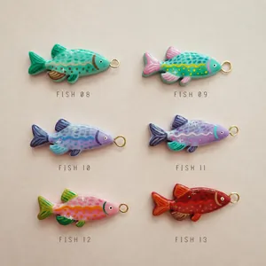 Detail view of 6 colorful fish-shaped 18K gold-plated pendants with hand-painted patterns