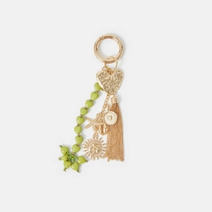 Détail de breloque de sac bohème avec perles cœur vertes et pendentifs dorés