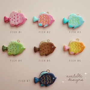 Detailed view of colorful fish-shaped 18K gold-plated pendants in seven vibrant patterns