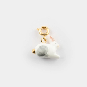 Vue macro détaillée d'un pendentif lapin blanc avec fermoir doré et finition en or 18 carats