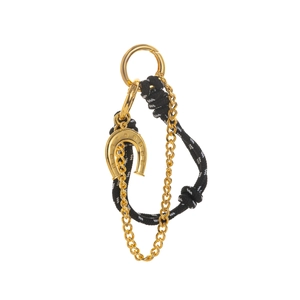 Detail of golden horseshoe pendant with black and white woven rope and metallic chain