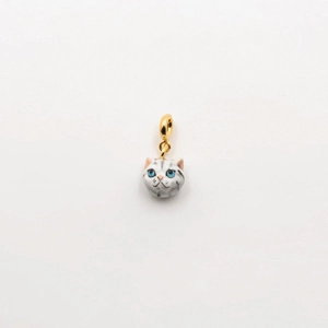 Détail d'un pendentif chat avec anneau en or 18 carats, yeux bleus et motif tabby argenté