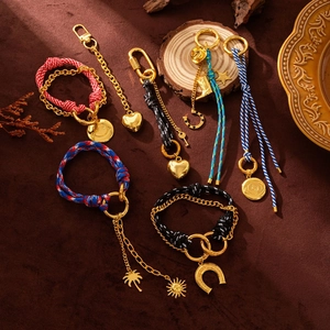 Detailed close-up of woven rope charms with gold alloy pendants on vintage wood background