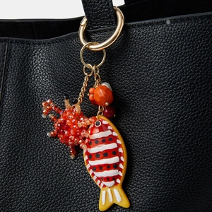 Bijou de sac poisson artistique avec perles rouges et anneau doré sur cuir noir