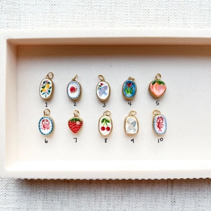 Detailset mit 10 bunten Emaille-Anhängern mit Früchten und Tieren und Goldbeschichtung
