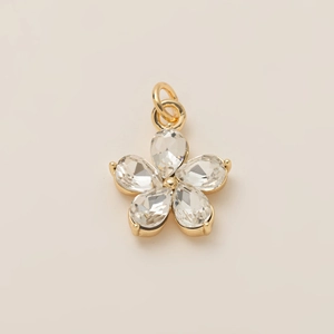 Detalle del colgante de flor de 5 pétalos en cobre chapado en oro 18K y cristal claro
