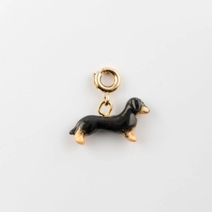 Détail d'un pendentif teckel en émail avec fermoir plaqué or 18K sur fond gris dégradé
