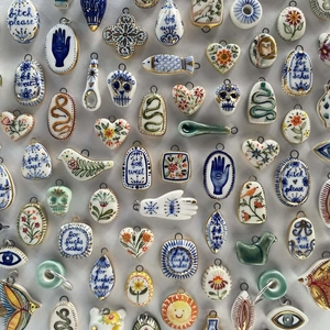 Ceramic skull and evil eye pendants with hand-painted 18K gold accents and blue patterns