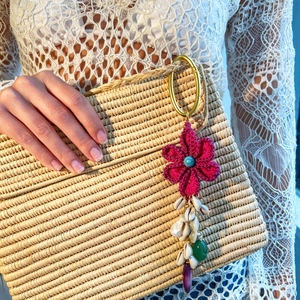 Détail d'un porte-clés fleur au crochet avec des coquillages naturels et pierres gemmes