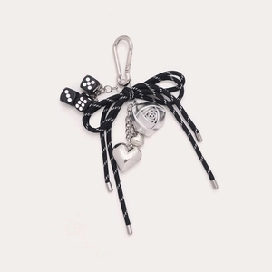 Détail d'un porte-clés style punk avec cœurs argentés et nœud noir et blanc