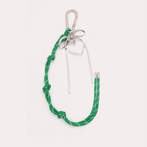 Détail du porte-clés DIY tressé vert avec un nœud argenté et un pendentif cœur