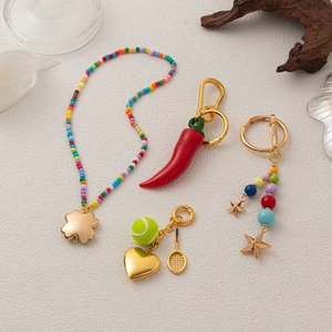 Handmade woven keychains with colorful beads, chili charms, and gold accents on white background