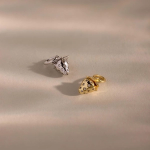 Detalle de los colgantes de fresa con circonitas brillantes en oro y plata