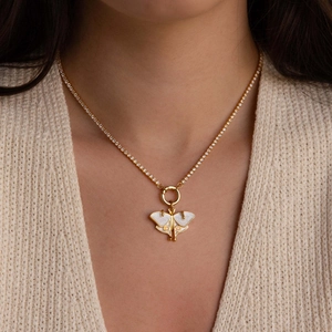 Exquisito collar de mariposa bañado en oro con esmalte blanco y una brillante cadena tennis
